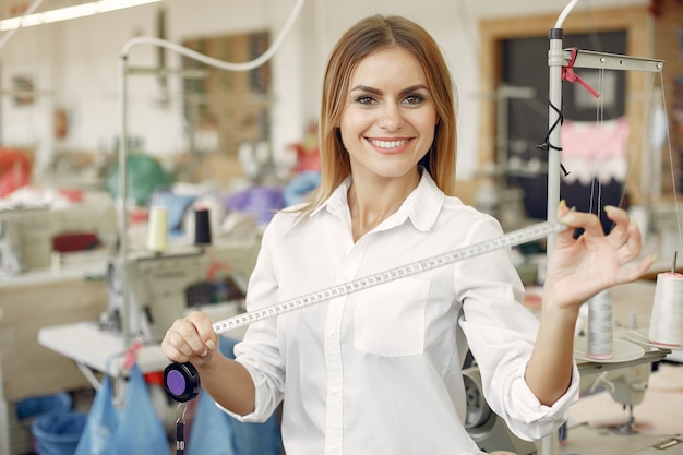 Woman standing in the factory with a thread