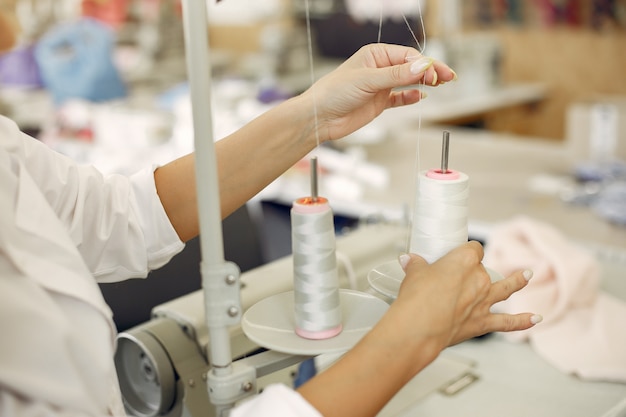 Woman standing in the factory with a thread