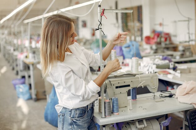 Woman standing in the factory with a thread