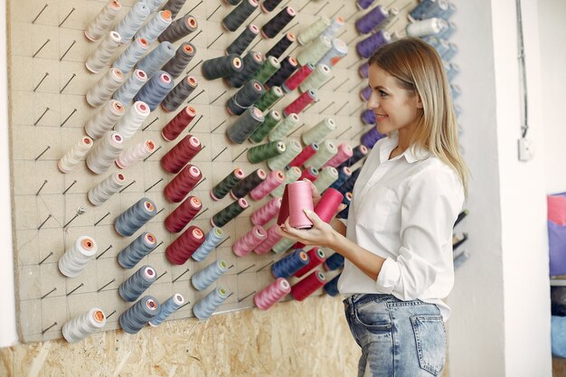 Woman standing in the factory with a thread