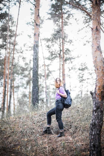 Foto gratuita donna in piedi sulla collina della foresta