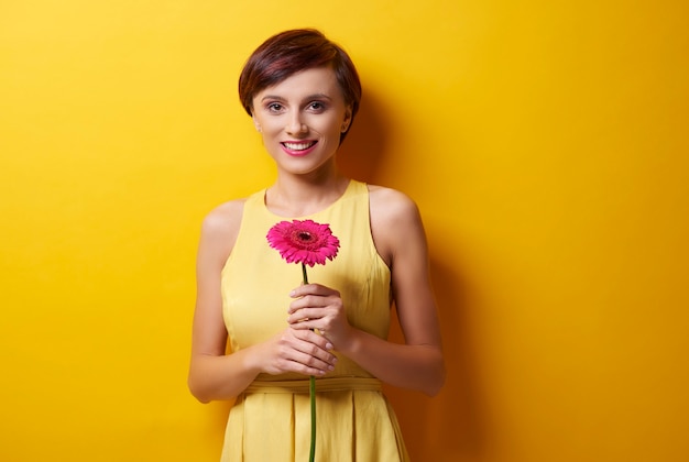 Woman standing in front of camera with flower