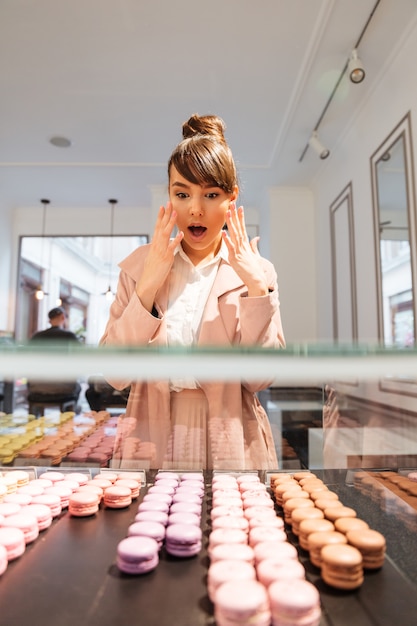 Woman standing in front of the glass showcase with pastries