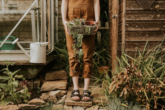 Woman standing in front of the shed with houseplant