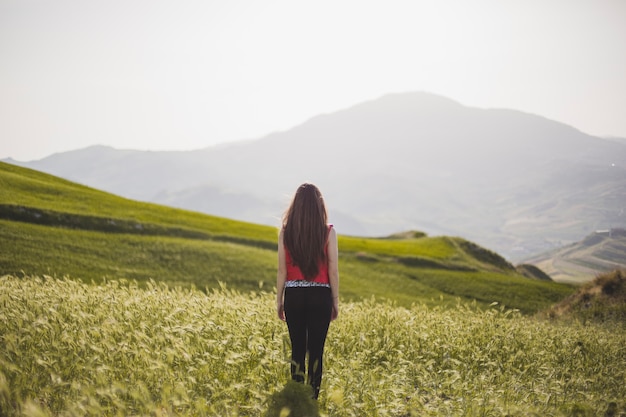 女性、草の上に立つ