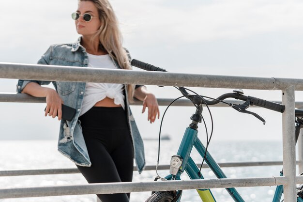 Foto gratuita donna in piedi accanto alla sua bici