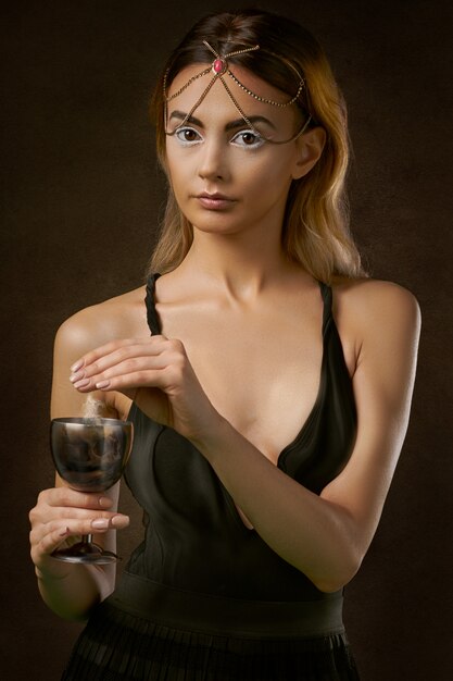 Женщина стоит и держит бокал вина