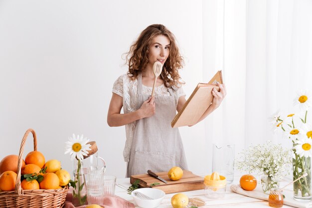 Woman standing indoors near table with a lot of citruses