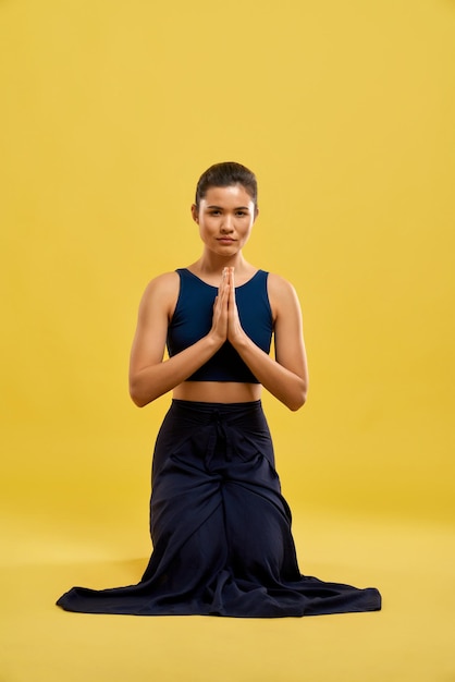 Free photo woman standing on knees holding prayer hands