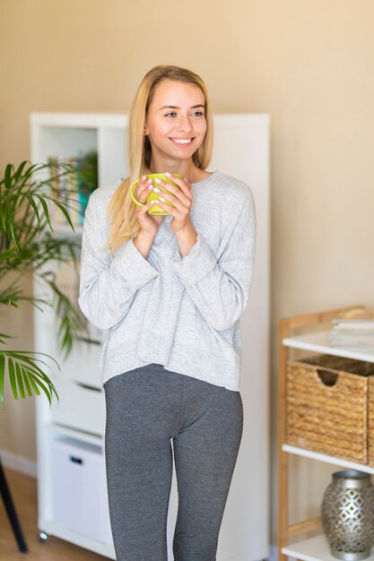 Free photo woman standing in the living room and looking away