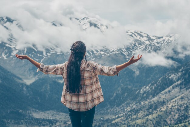 женщина стоит и смотрит на горы в природе