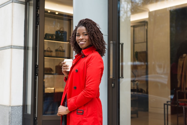 Woman standing near shop and smiling