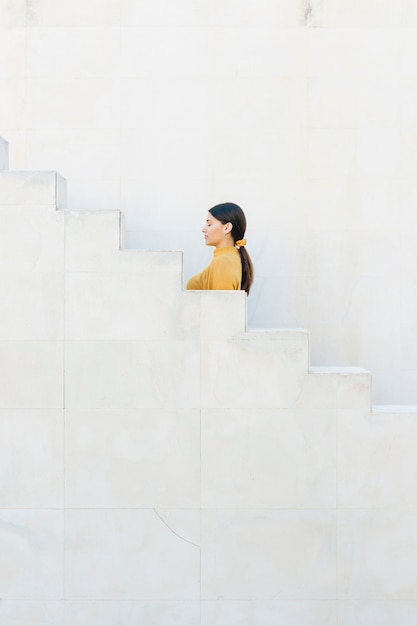 Free photo woman standing near staircase with her eyes closed
