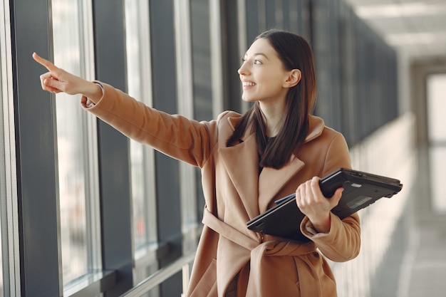 Woman standing in the office with a laptop