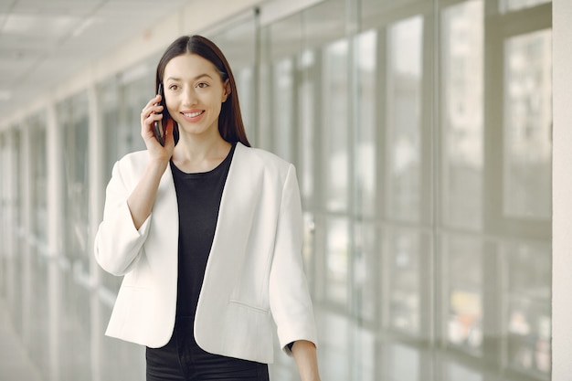 Woman standing in the office with a phone