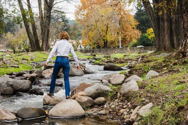 Woman standing on river rocks