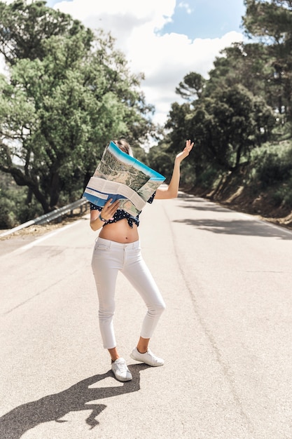 Woman standing on road looking at map