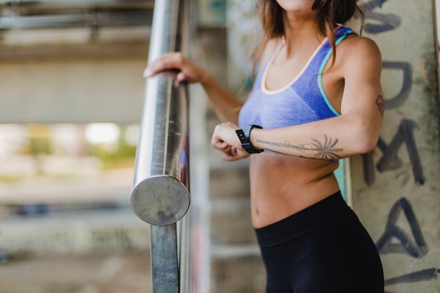 Free photo woman standing on stairs looking at watch