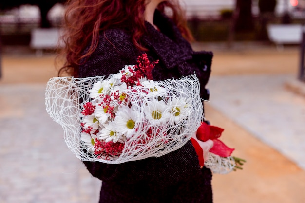 Woman standing in street with flowers