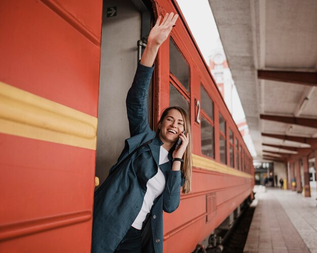 電車の入り口に立って手を振っている女性