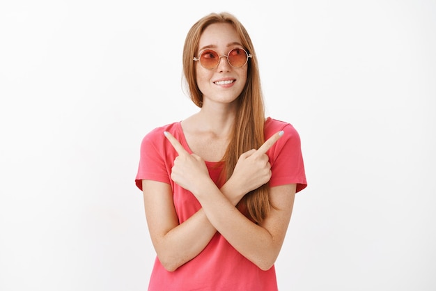 Woman standing between two choices having doubts what better pointing in different sides with crossed hands on chest looking right and smiling as if having decided what deal take