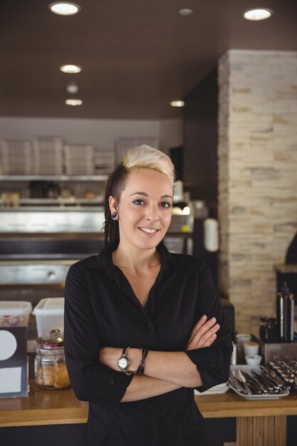 Woman standing with arms crossed in kitchen