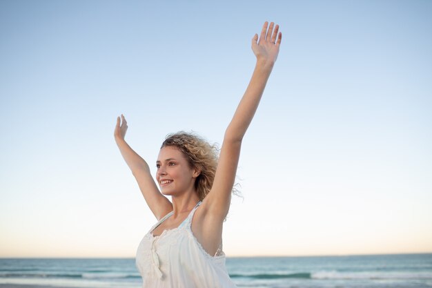 Женщина с поднятыми руками на пляже