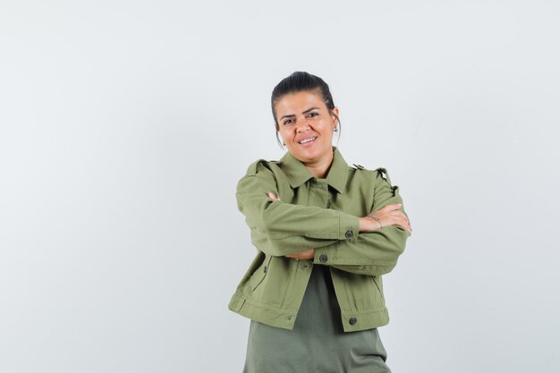 woman standing with crossed arms in jacket, t-shirt and looking confident.