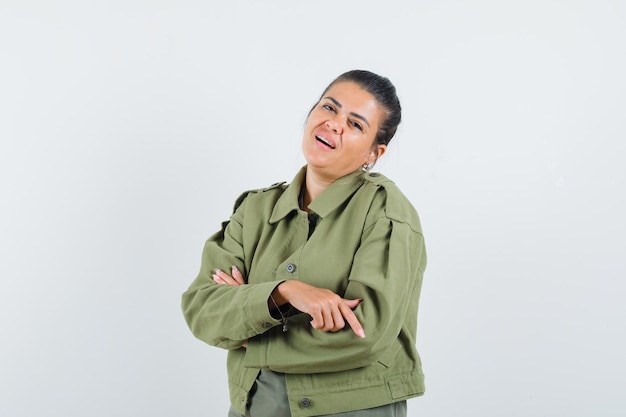 woman standing with crossed arms in jacket, t-shirt and looking confident