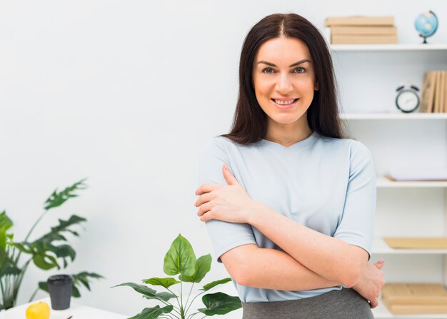 Woman standing with crossed arms in office