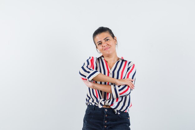 woman standing with crossed arms in shirt, skirt and looking proud.