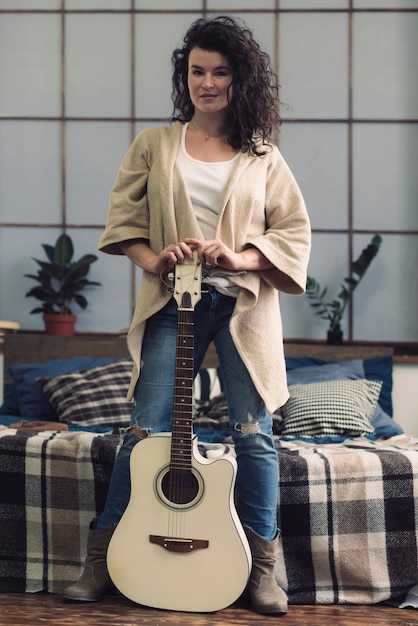 Free photo woman standing with guitar