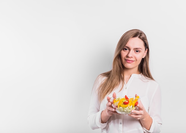 Woman standing with vegetable salad in bowl