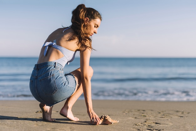 Foto gratuita donna accanto a stelle marine in spiaggia