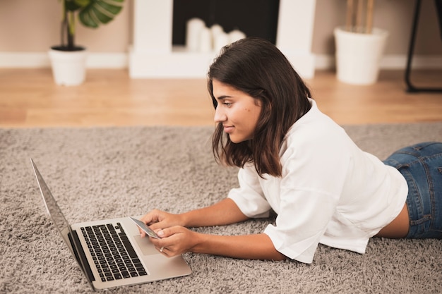 Free photo woman staying on floor and working on laptop