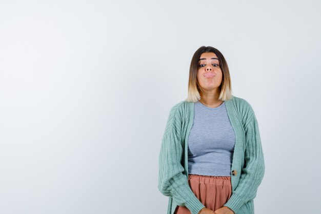 Foto gratuita donna che attacca fuori la lingua in abiti casual e guardando divertente, vista frontale.