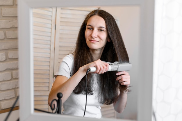 Free photo woman straightening her hair