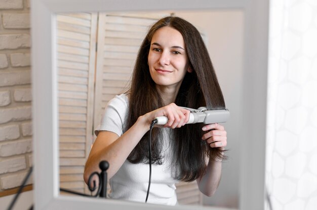 Woman straightening her hair