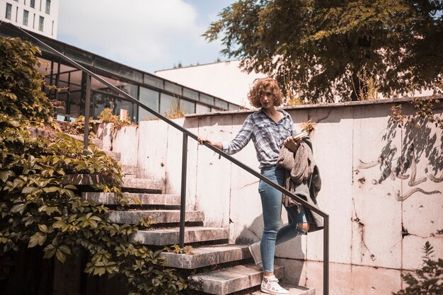 Woman in street wear going down on steps