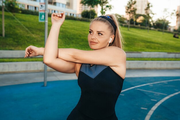 Woman stretches muscles in the outdoor gym