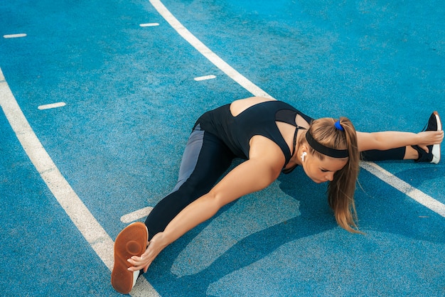 Woman stretches muscles in the outdoor gym