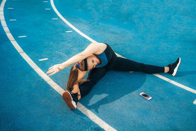 Woman stretches muscles in the outdoor gym