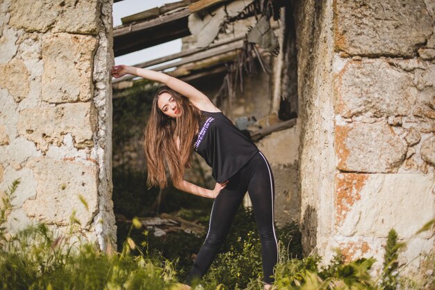 Woman stretching at abandoned building