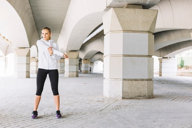 Woman stretching arms on street