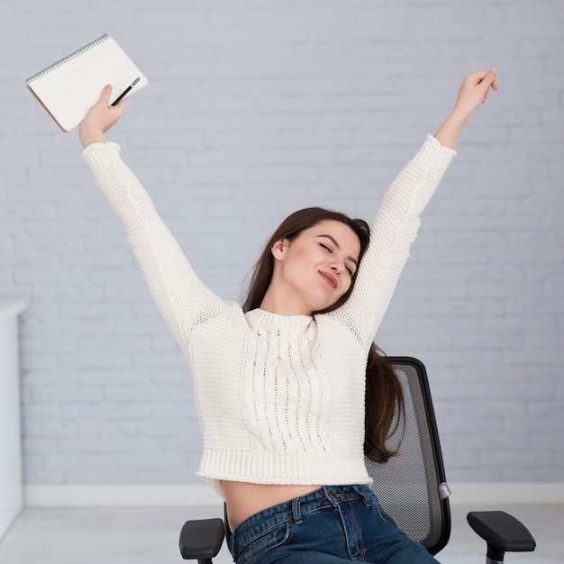 Woman stretching on chair in office