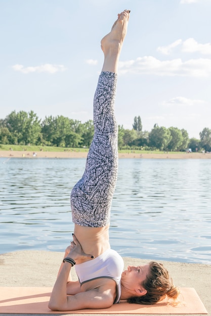 Free photo woman stretching and concentrating at river