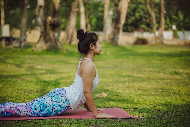 Free photo woman stretching laying on the grass