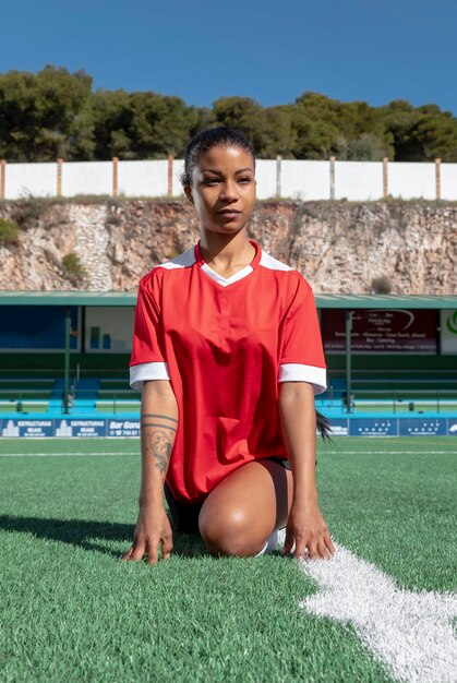 Woman stretching leg on field