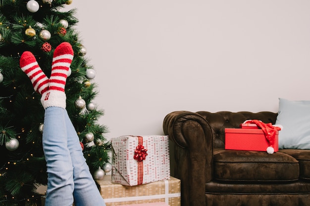 Woman stretching legs in front of christmas tree