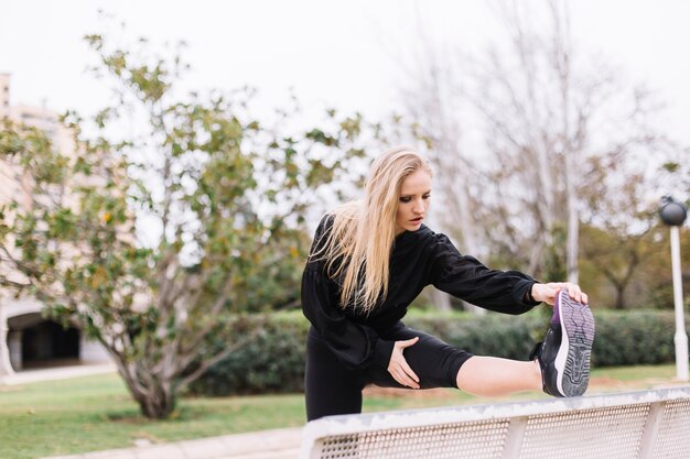 Woman stretching legs on street